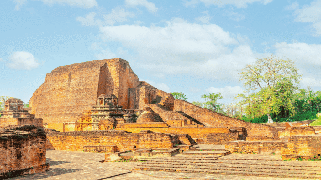 Nalanda Mahavihara.Buddhist monk walking through Nalanda Mahavihara ruins Bihar India