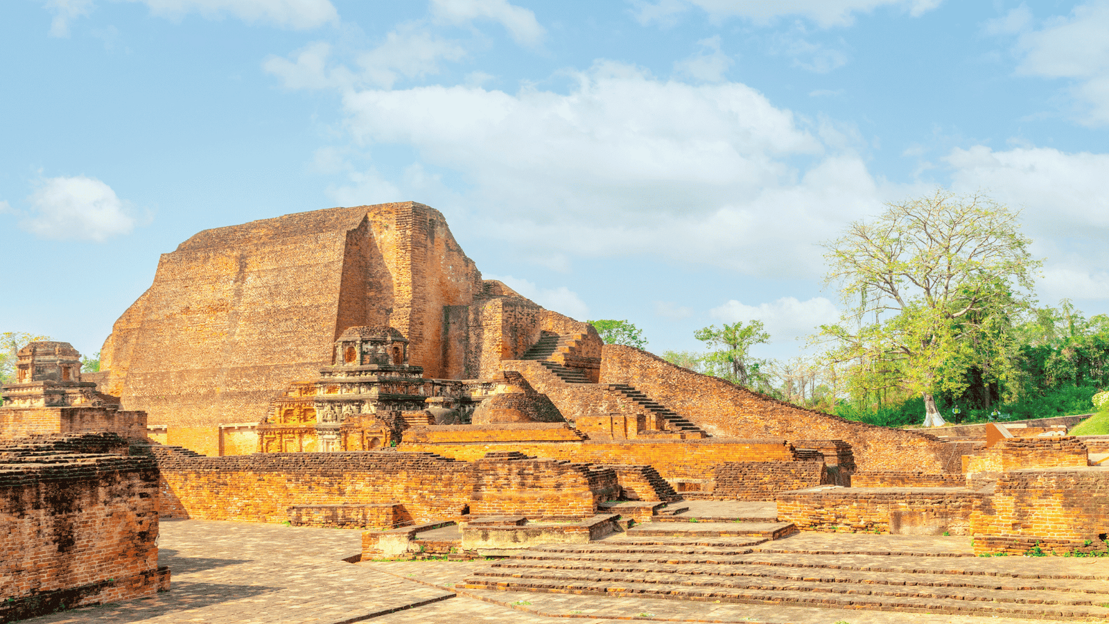 Nalanda Mahavihara.Buddhist monk walking through Nalanda Mahavihara ruins Bihar India